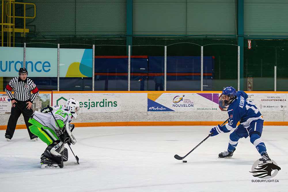 Smith and Assinewai leading by example 38 Samuel Assinewai wearing the blue jersey skates in on the Espanola Paper King's goaltender wearing a white jersey with bright green pants, during a shootout prior to the holiday break.