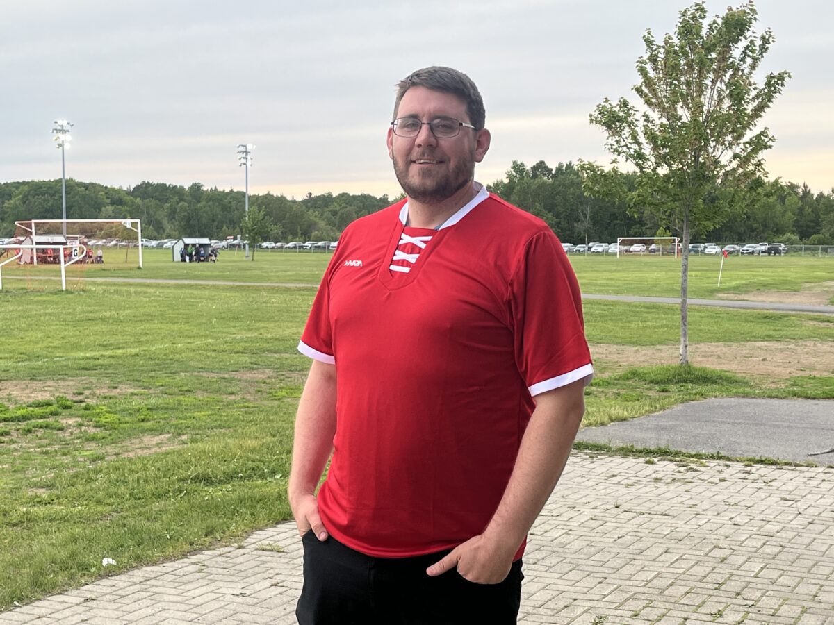 Coach Tim Marsh poses with a red jersey on